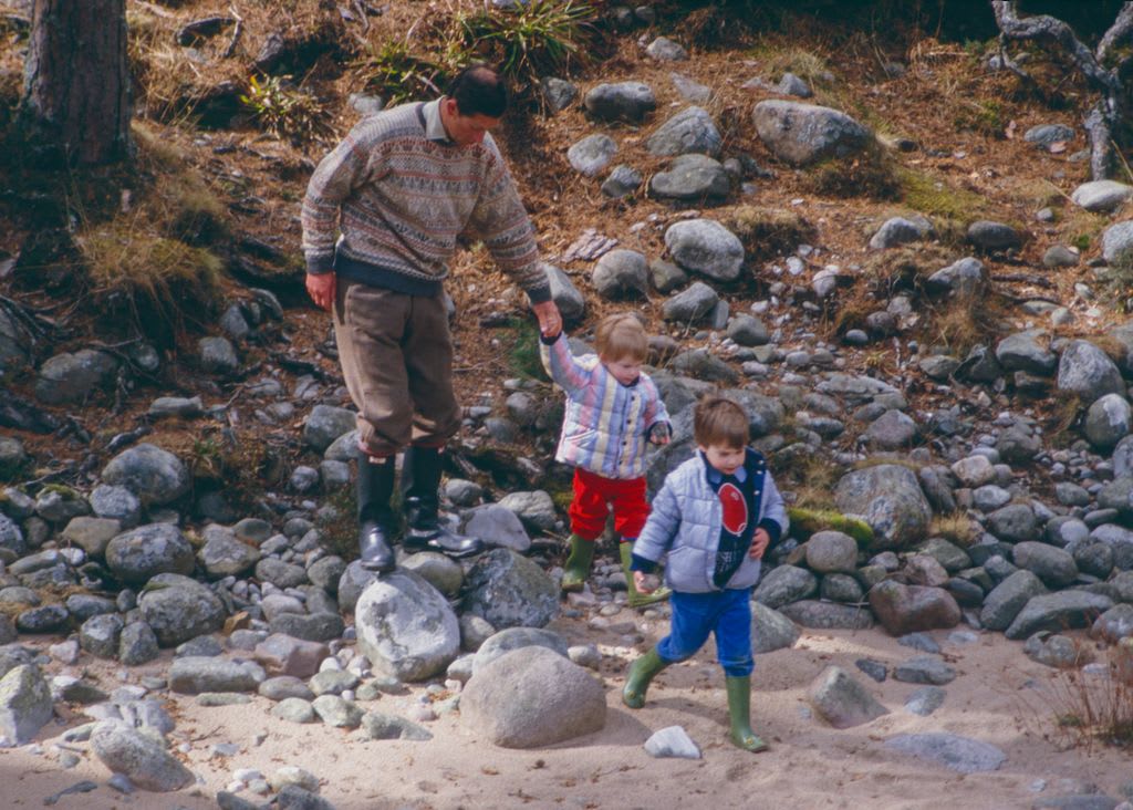 Charles, Prince of Wales, Prince William, and Prince Harry play on the bank of the River Dee, near Balmoral Estate, Scotland, on April 10,1987, in Ballater, Scotland.
