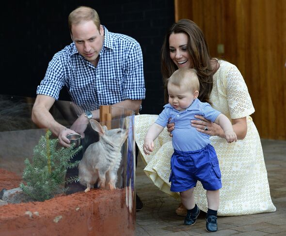 Kate and William hold baby George by zoo enclosure
