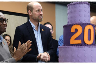 Prince William smiling as he receives an enormous cake to celebrate an important milestone